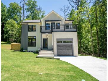 Modern two-story home with a balcony, attached garage, and well-manicured lawn at 4366 Bradley Sw Dr, Snellville, GA 30039
