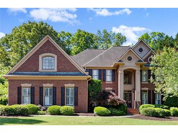 A classic brick home featuring a manicured lawn and lush landscaping, embodying suburban elegance at 1860 Hill Chase, Alpharetta, GA 30022