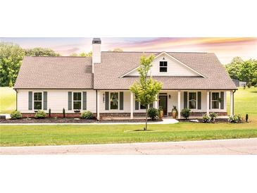 Charming single-story home featuring a covered porch, gray shutters, and a beautifully landscaped yard at 2980 Hd Atha Rd, Covington, GA 30014