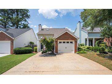 Charming home with a brick-accented garage and well-manicured lawn at 1822 Commonwealth Dr, Woodstock, GA 30188
