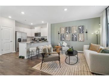 Open-concept living room featuring modern decor, stylish furniture, and a breakfast bar connected to the kitchen at 2363 Haran Dr # 35, Lithonia, GA 30058