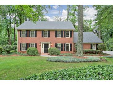 Charming two-story brick home featuring a well-manicured lawn and mature trees at 3564 Liberty Ln, Marietta, GA 30062