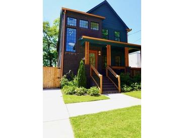 Charming two-story home featuring dark brick, wood trim, and a welcoming front porch at 1122 Rice Nw St, Atlanta, GA 30318
