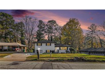 Charming home featuring a manicured lawn, and beautiful contrasting black shutters, all set under a picturesque twilight sky at 2178 Shamrock Dr, Decatur, GA 30032