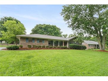 Charming brick home featuring a large front yard with mature trees and manicured shrubs at 2644 Hickory Valley Dr, Snellville, GA 30078