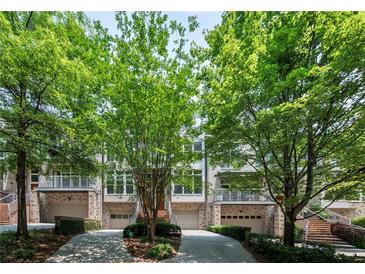 Stunning townhomes boasting manicured lawns, driveways and staircases leading to covered balconies, complemented by mature landscaping at 1308 Fernwood Ne Cir, Atlanta, GA 30319