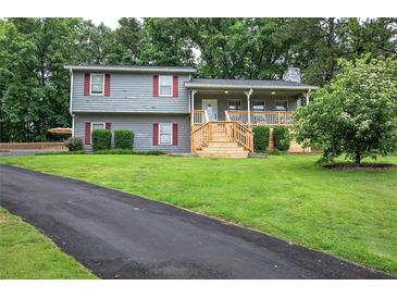 Charming two-story home featuring a spacious front yard, inviting porch, and well-maintained landscaping at 123 Mill Ln, Dallas, GA 30157