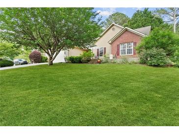 Charming home featuring a lush green lawn and mature trees at 117 Laguna Springs Dr, Woodstock, GA 30188