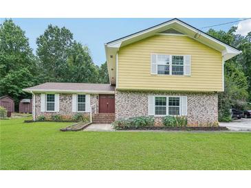 Charming two-story home with a brick facade and a well-manicured front lawn at 2201 Colonial Oak Way, Stone Mountain, GA 30087