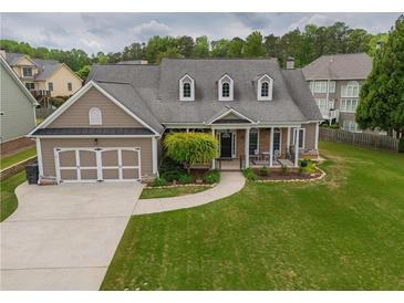Charming home features a two-car garage and a well-manicured front lawn and an inviting front porch at 4721 W Lakeshore Dr, Acworth, GA 30101