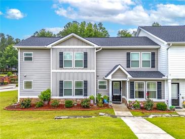 Charming two-story townhome featuring a well-manicured lawn and inviting front entrance at 6330 Garden Cir, Douglasville, GA 30135
