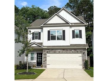 Charming two-story home features white siding, stone accents, a two-car garage, and a manicured lawn at 158 Bryon Ln, Acworth, GA 30102
