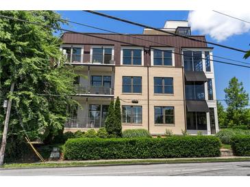 Modern condo building featuring balconies, awnings, and a landscaped front yard at 281 15Th Ne St # 202, Atlanta, GA 30309