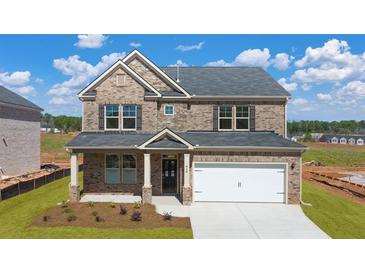 Beautiful brick home with a two car garage and well manicured front yard at 113 Canal St, Hampton, GA 30228