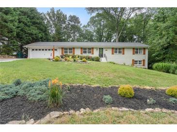 Charming ranch-style home with white painted brick, wood shutters, and a lush, green front lawn at 2109 Allgood Rd, Marietta, GA 30062