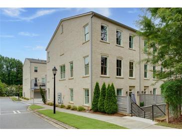 Charming brick townhome with multiple windows and lovely landscaping at 302 Boxwood Ln, Roswell, GA 30075