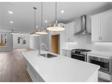 Bright kitchen boasts a large island with quartz countertops and stainless steel appliances at 5448 Howington E Ct # 194, Buford, GA 30518