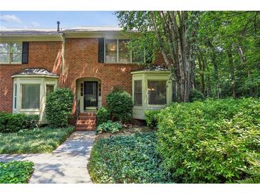 Charming brick townhouse with well-maintained landscaping and bay windows at 1386 Sheffield Glen Ne Way, Atlanta, GA 30329