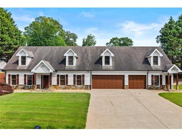 Charming home featuring a well-maintained lawn, a 3 car garage and classic dormer windows at 150 South St, Buford, GA 30518