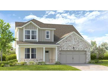 Inviting two-story home featuring a covered porch, neutral siding, brick accents, and a two-car garage at 4171 Brindle Pl, Loganville, GA 30052