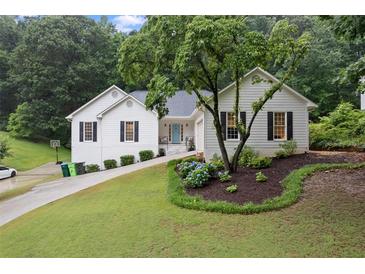 Charming home boasts a well-manicured lawn, complemented by classic black shutters and a pop of color from the front door at 3543 Pine Grove Dr, Douglasville, GA 30135
