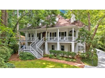Charming two-story white home featuring double porches and lush green landscaping at 400 Old Ivy Ne Rd, Atlanta, GA 30342