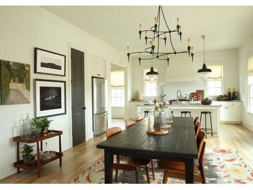 Open concept dining room with dark wood table, chandelier, and stylish decor adjacent to the modern kitchen at 2067 Telfair Circle # A&B, Atlanta, GA 30324