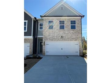 New construction home showcasing a two-car garage and light brick facade with complementary gray trim and matching roof at 5649 Hislop Ln # 90, Mableton, GA 30126
