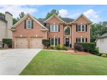 Charming two-story brick home with a well-manicured lawn and a two-car garage in a beautiful suburban neighborhood at 2772 Hillgrove Dr, Dacula, GA 30019