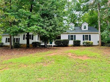 Charming single-story home with dormer windows and a lush, wooded front yard at 1905 Sidneys Cv, Lawrenceville, GA 30043