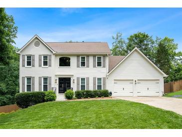 Charming white two-story home with a well-manicured lawn and a two-car garage at 3710 Robinson Walk Ct, Marietta, GA 30068