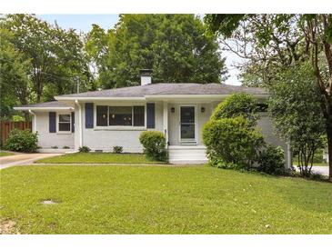 Charming home with manicured lawn, white painted brick, and blue shutters at 1060 Pinedale Se Dr, Smyrna, GA 30080
