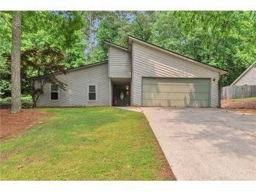 Charming single-story home with neutral siding, attached garage, and well-manicured lawn surrounded by mature trees at 2000 Kristian Way, Roswell, GA 30076