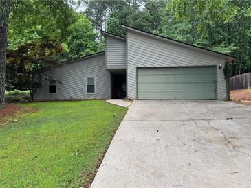 Charming single-Gathering home featuring a large garage, driveway, and well-maintained lawn at 2000 Kristian Way, Roswell, GA 30076