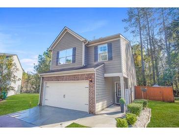 Charming two-story home featuring a brick facade and a two-car garage with an inviting front lawn at 3143 Bonnes Dr, Stonecrest, GA 30038