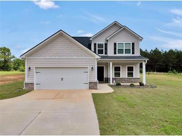 Charming two-story home with a two-car garage and well-manicured lawn at 715 Colvin Dr, Locust Grove, GA 30248