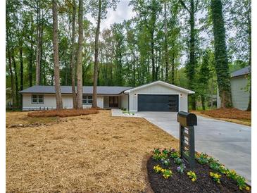 Charming one-story home with modern garage door and beautifully landscaped front yard at 1329 Hidden Hills Pkwy, Stone Mountain, GA 30088