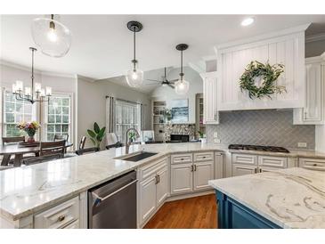 Bright, open kitchen with granite countertops, a center island, and stainless steel appliances at 5173 Brendlynn Dr, Suwanee, GA 30024