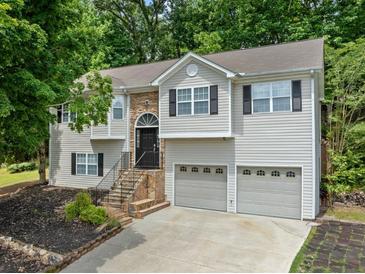 Charming two-story home with stone accents, gray siding, black shutters, and a two-car garage at 2623 Lone Oak Nw Trl, Kennesaw, GA 30144