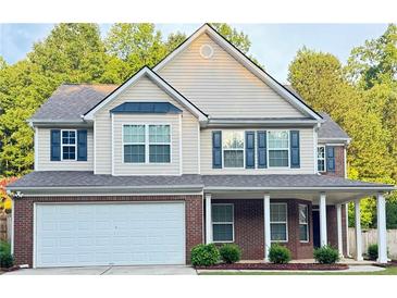 Charming two-story home featuring brick accents, a covered porch, and a well-maintained front yard at 5421 Skylar Creek Ln, Buford, GA 30518