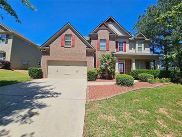 Charming two-story brick home with a well-manicured lawn and two-car garage at 1021 Rock Elm Dr, Auburn, GA 30011