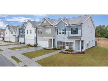 New townhomes feature colorful exteriors, front lawns, garages, sidewalks, and professional landscaping for curb appeal at 1029 Merritt Dr # 97, Villa Rica, GA 30180