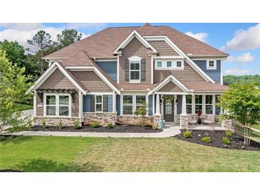 Charming two-story home with a beautiful landscaped yard, stone accents, and a welcoming front porch at 2121 Harmony Dr, Canton, GA 30115