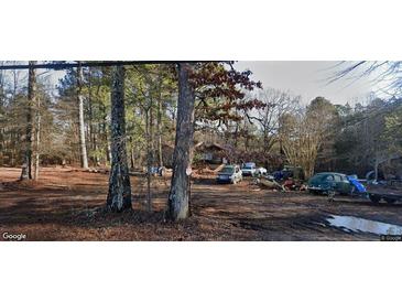 Property showing a house situated on an expansive lot with mature trees, with multiple cars parked outside at 594 Collinsworth Rd, Palmetto, GA 30268