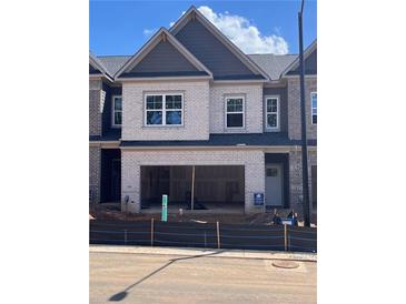 Charming townhome with a white brick facade and an attached two-car garage at 3104 Marbella Cir # 2, Kennesaw, GA 30152
