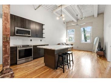 Modern kitchen featuring stainless appliances, a center island with bar stools, and abundant natural light at 210 Walker Sw St # 3, Atlanta, GA 30313