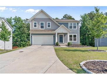 Charming two-story home featuring a two-car garage, landscaped yard, and modern architectural details at 6065 Crescent Landing Dr, Cumming, GA 30028