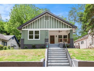 Charming craftsman-style home featuring a large front porch, green siding, and a well-maintained front yard at 905 Gaston Sw St, Atlanta, GA 30310
