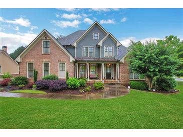 Inviting two-story home with a brick facade, manicured landscaping, and lush green lawn on a sunny day at 26 Trillium Ln, Acworth, GA 30101