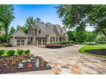 Beautiful brick home with a three-car garage, manicured landscaping, and a circular driveway at 771 Tate Overlook, Marietta, GA 30064